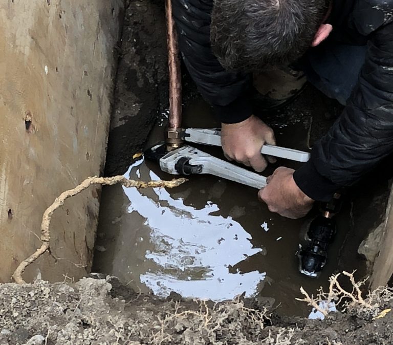 ouvrier en train de remplacer une entrée d'eau